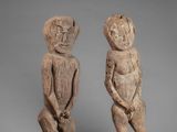 two wooden figures of a man and a woman standing next to each other