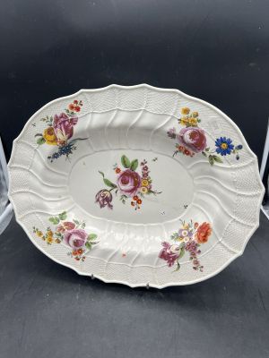 une photo d'une assiette décorée de fleurs, posée sur une table