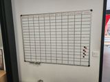 a white board on the wall next to a toilet