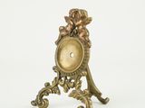 une petite horloge ornée d'un cerf, posée sur un socle