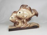 a figurine of a fish and a fish on a wave