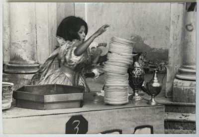 photographie en noir et blanc d'une femme en train de disposer des assiettes sur une table