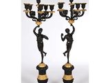 une paire de chandeliers noirs et dorés ornés de figures