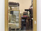 a mirror that is sitting on the floor in front of a chair