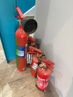 un extincteur posé à côté d'une borne d'incendie, au sol