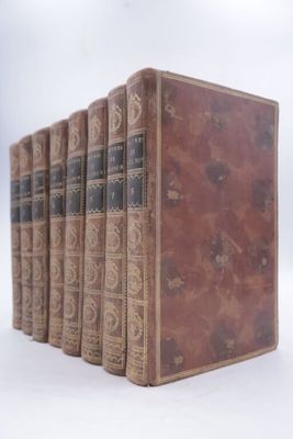 four old books sitting on top of each other on a white surface