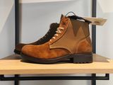des bottes marron exposées sur une étagère dans un magasin de chaussures