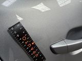 a sticker on the hood of a car with a ruler attached to it