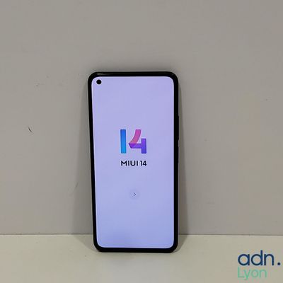 a close up of a phone on a table with a logo on the screen