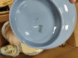 a person holding a blue bowl in a box