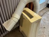 a small air conditioner sitting next to a radiator