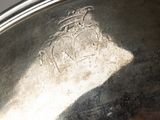 a close up of a silver plate with a crown on it