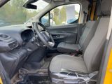 the interior of a yellow van with a steering wheel and a bag in the passenger seat