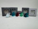quatre petites figurines de poissons en verre rangées dans une boîte