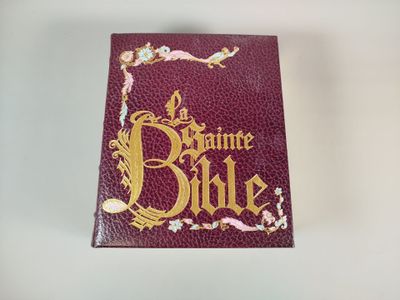 un livre rouge orné de lettres dorées, posé sur une table