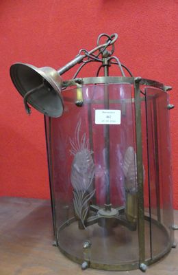 une lanterne en verre surmontée d'une cloche en métal