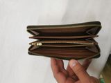 someone is holding a wallet that has two zippers on it