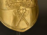 a gold helmet with a crest and two crossed swords on it