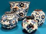 quatre vases posés sur une surface bleue