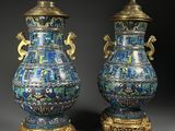 paire de vases bleus et dorés munis d’anses et posés sur des socles
