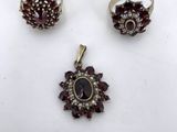 three rings and a ring with garnets on a white surface