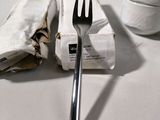a fork and a napkin on a table next to a cup