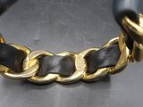 un gros plan d'un bracelet noir et doré posé sur une table