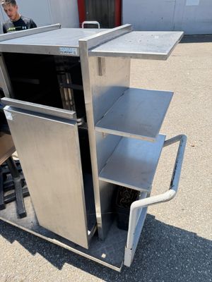 a man that is standing next to a cart with a microwave on it