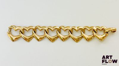 un gros plan sur un bracelet en or orné de cœurs