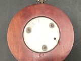 a wooden clock hanging on a wall on a table