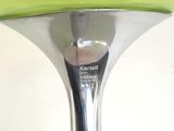 a green vase with a silver base on a table