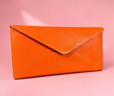 an orange envelope on a pink background