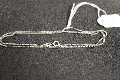 un gros plan d'une chaîne en argent à laquelle est accrochée une médaille