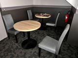 tables and chairs in a corner of a room with a fire extinguisher in the background