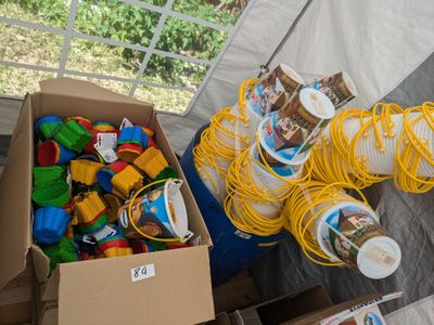 une boîte remplie de jouets et une boîte de tasses posées sur une table