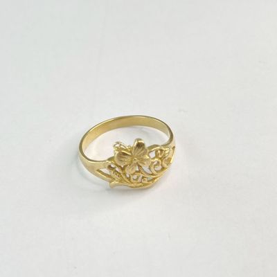 gros plan d'une bague en or sur une surface blanche