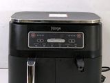 a black and silver air fryer sitting on a counter