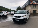 une camionnette blanche garée devant un bâtiment dans un parking