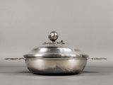 casserole en métal argenté surmontée d'un oiseau