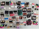 many pairs of earrings on display on a wall