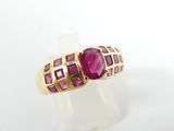 a close up of a gold ring with a ruby stone