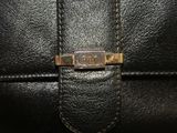 the inside of a black leather purse with a gold buckle