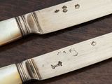 two knives that are sitting on top of a wooden table