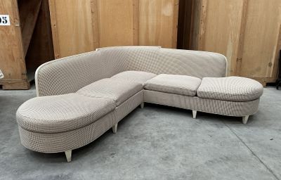 un canapé et un pouf dans une pièce aux murs en bois
