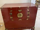 une commode rouge surmontée de décorations dorées