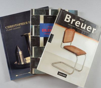trois livres posés sur une table blanche, avec une chaise et un vase
