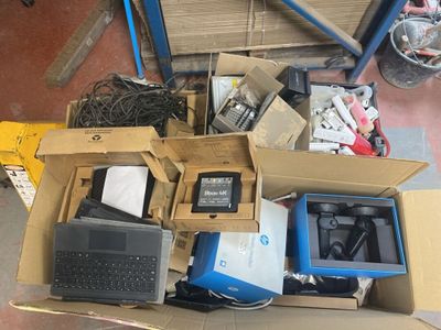 une boîte remplie d'appareils électroniques et un ordinateur portable posés par terre