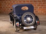 a small blue car parked in front of a brick wall