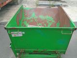 a green dumpster sitting in the middle of a parking lot