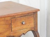 a small wooden table with a drawer on top of it